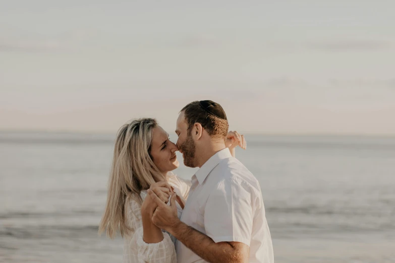 a man and woman are on a beach kissing