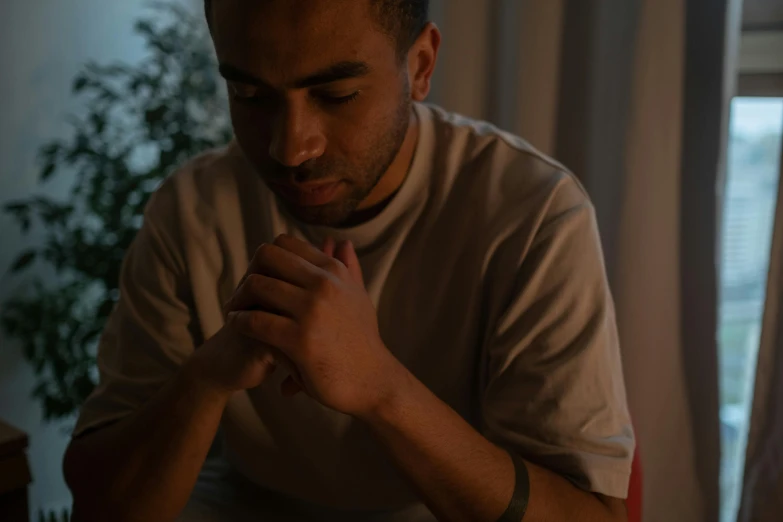 a man prays as he sits at his dinner table