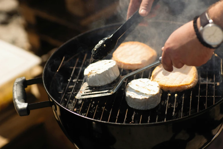 the grill has bread and small sandwiches on it