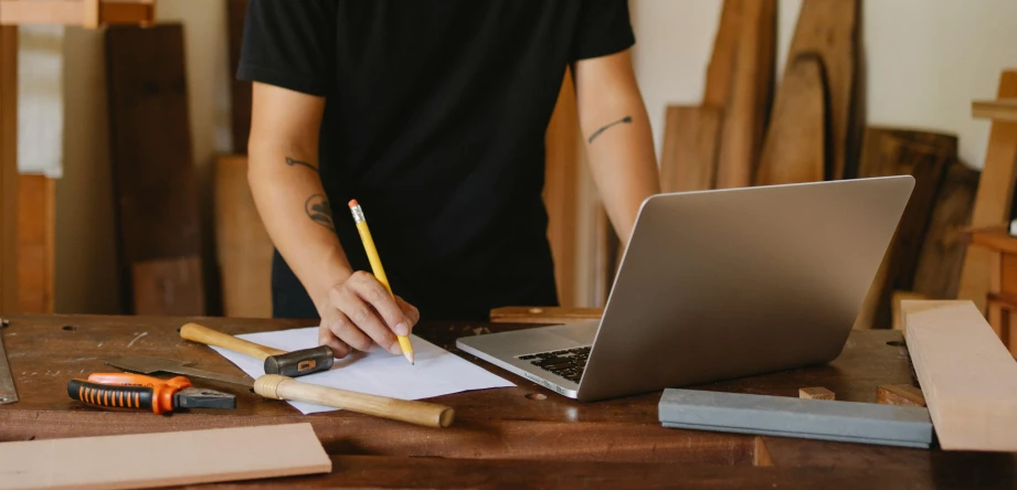 a man working on a laptop next to construction tools