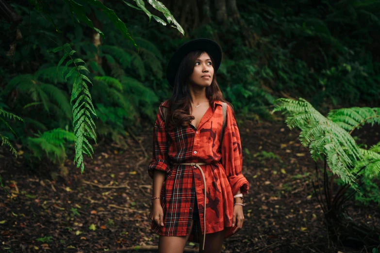 woman in dress and hat in dark forest