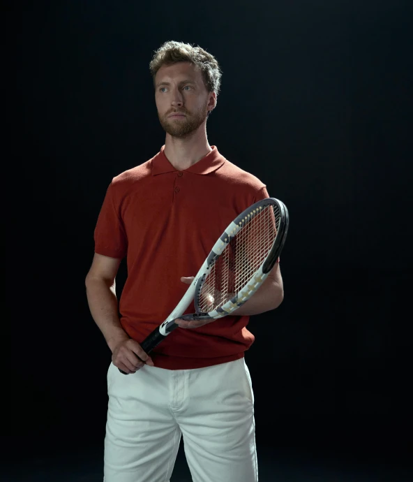 a man holding his tennis racket in one arm
