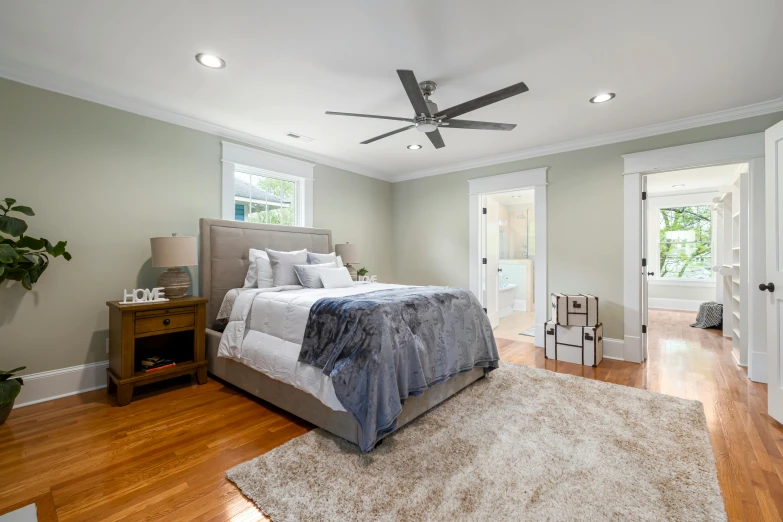 a clean bedroom with a bed and a ceiling fan