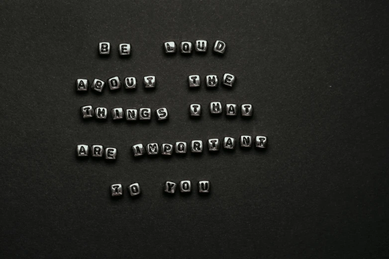 a group of ten metal beads sitting on top of a black table