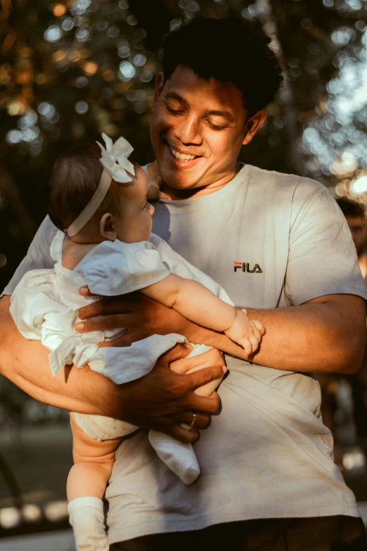 the man is holding the small child for her picture