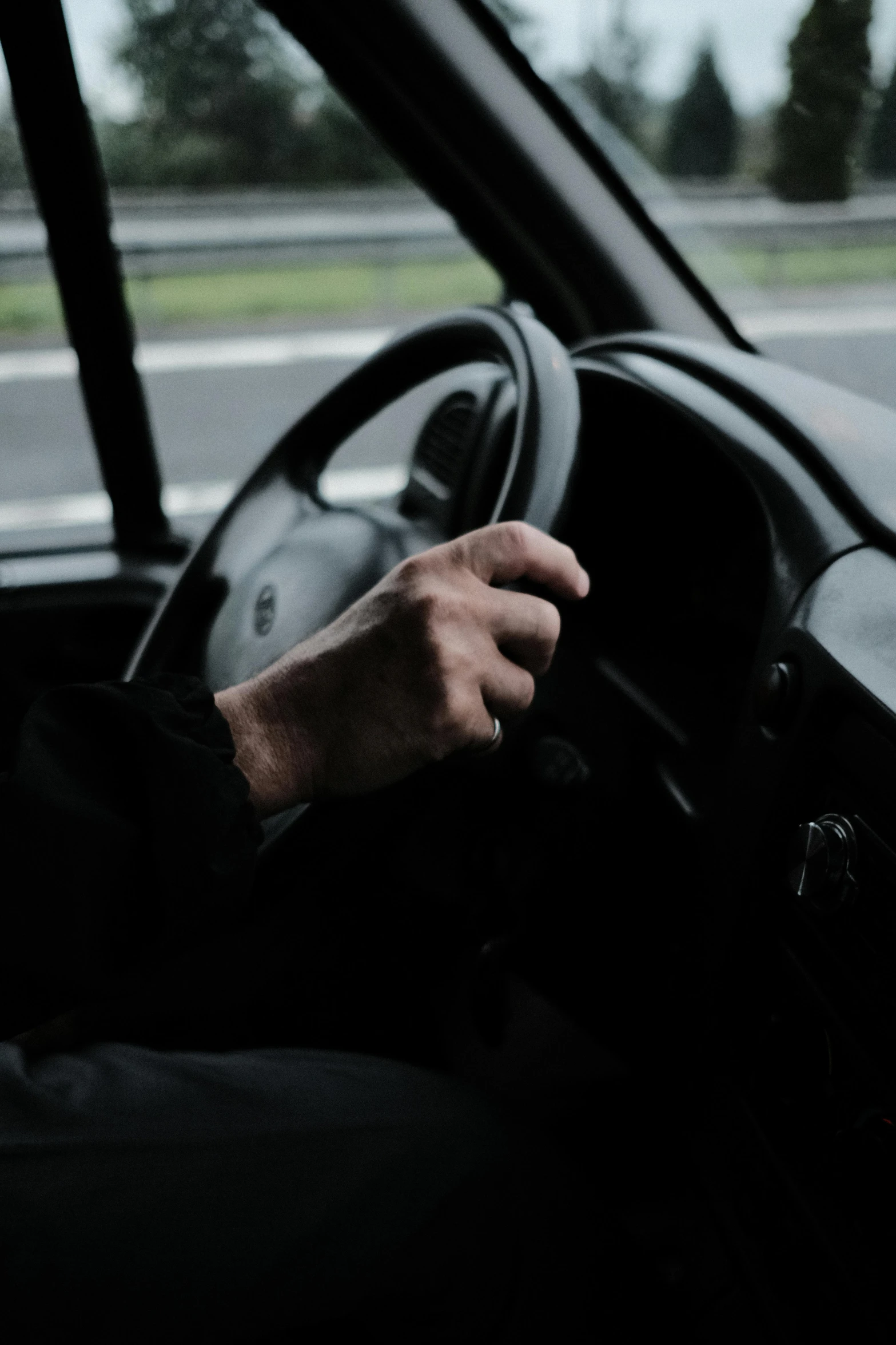 man's hand on steering wheel as viewed from car