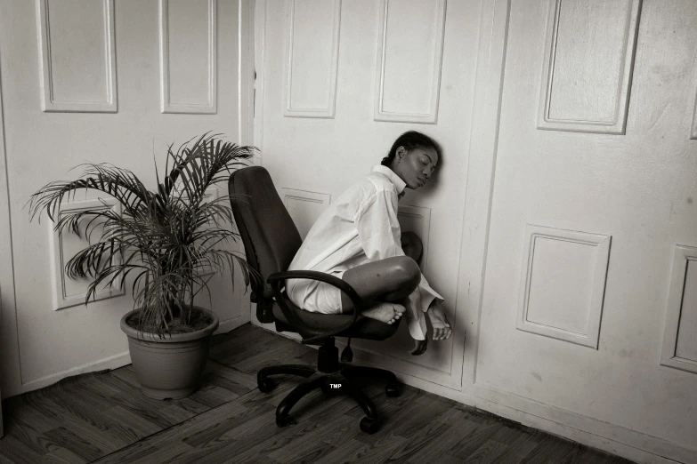 a black and white po of a man sitting in an office chair