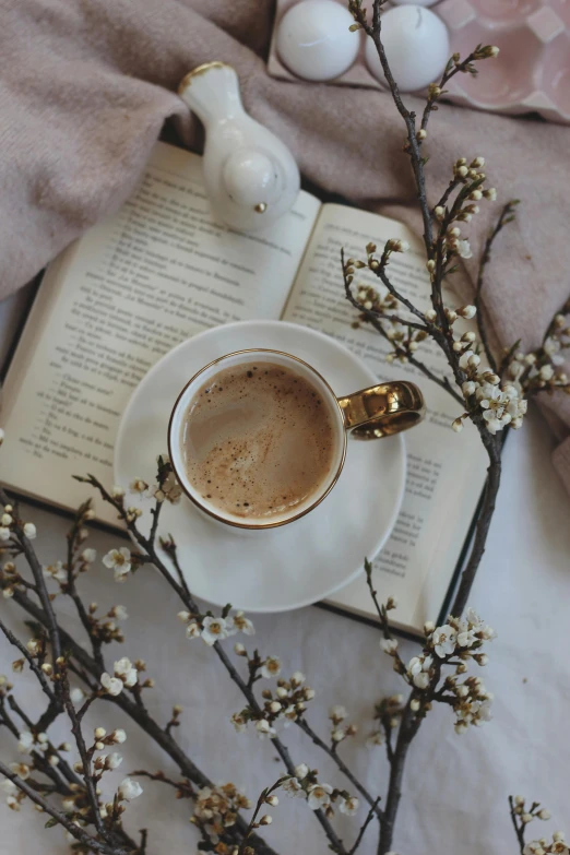 a coffee mug that is sitting next to an open book