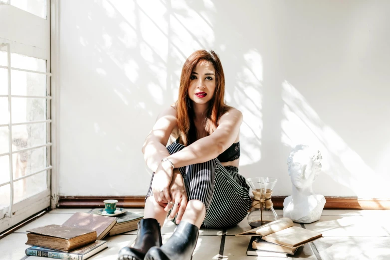 the woman sits on the floor surrounded by the objects