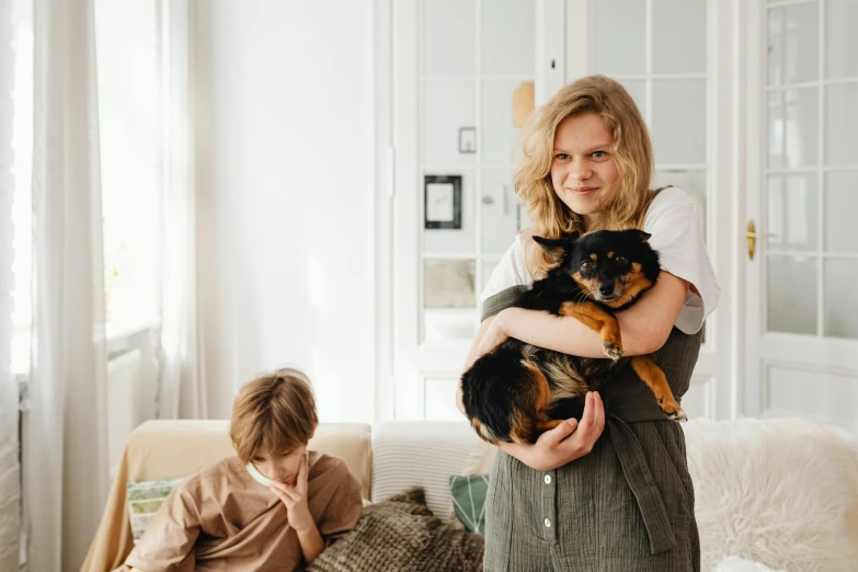 a woman holding two small dogs in a living room
