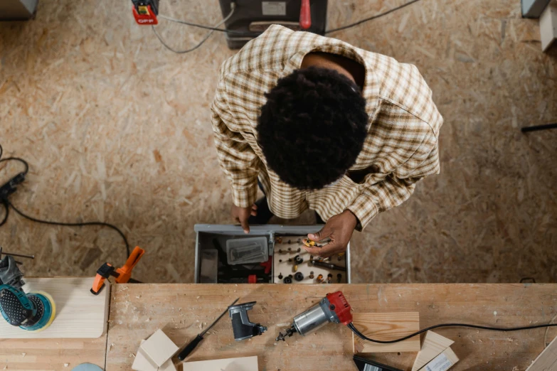 an overhead s of a man assembling wood tools