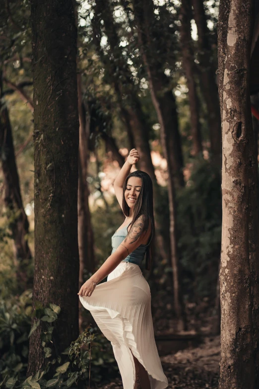 a young woman is standing in the woods