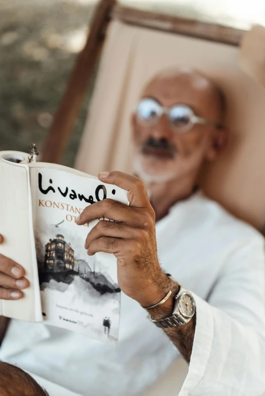 the man is reading a book in his chair