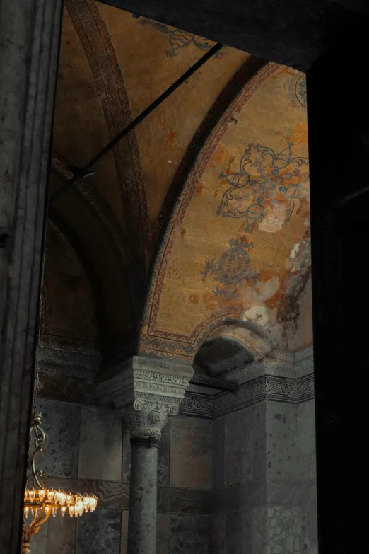 a chandelier hangs from a ceiling in an ornate, ancient room