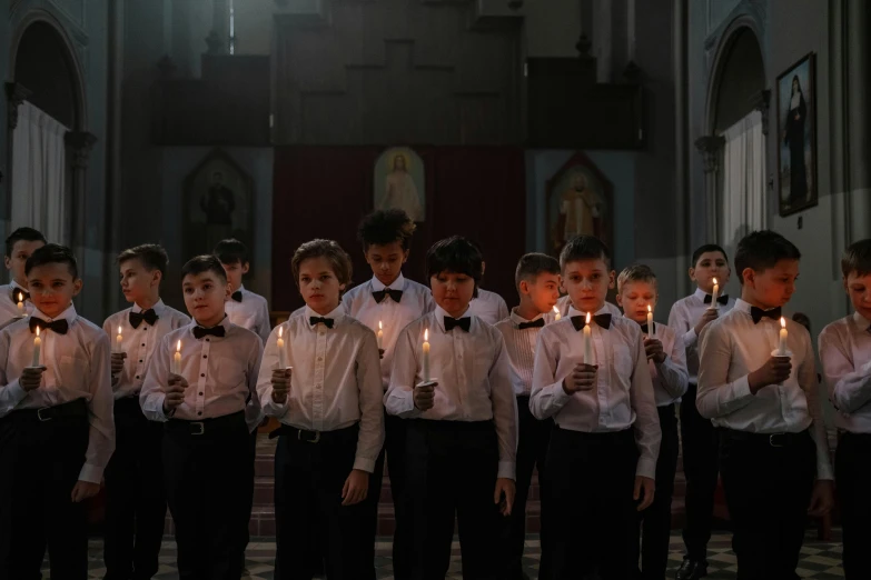 a group of s are wearing suspenders and holding candles