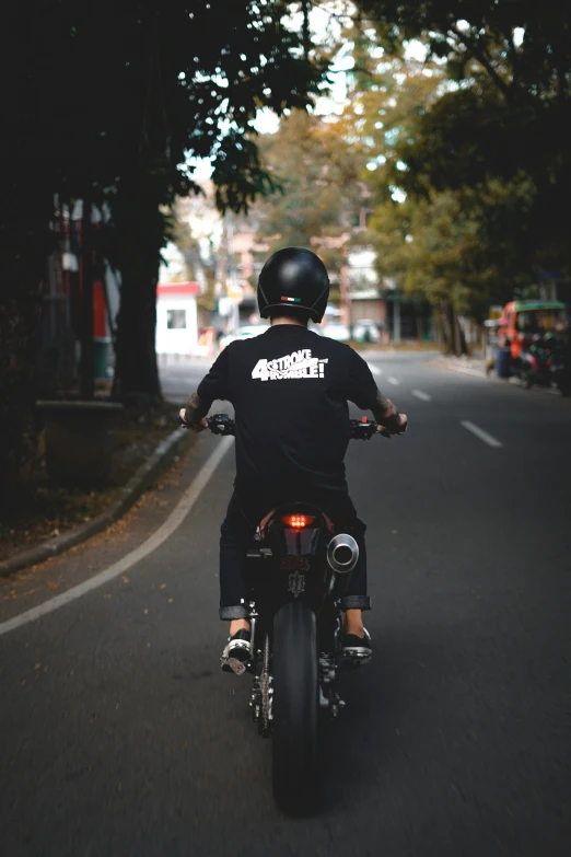 the person on a motorcycle wearing a helmet is going around the street