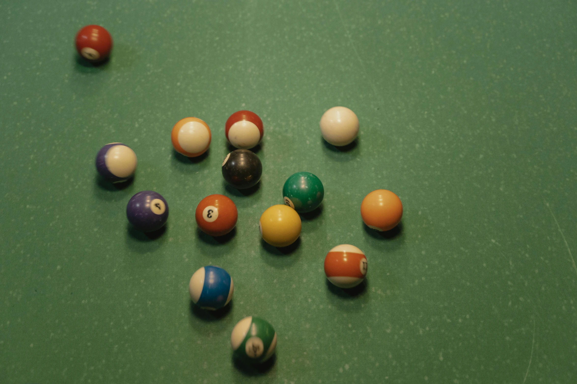 several pool balls on a green pool table