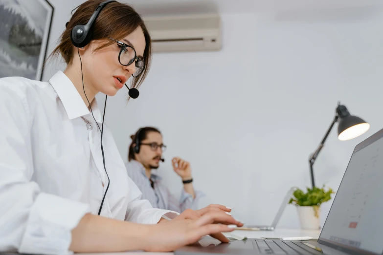 the woman in glasses is working on a laptop