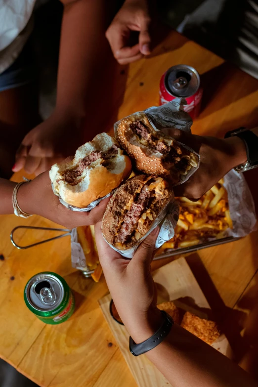 several people hold plates filled with food and cups