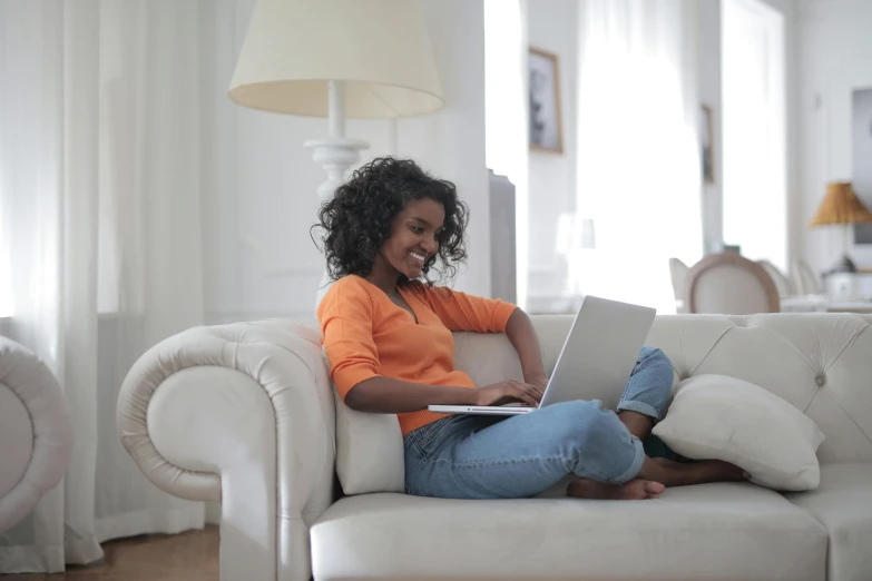 a girl is sitting on a couch and smiling