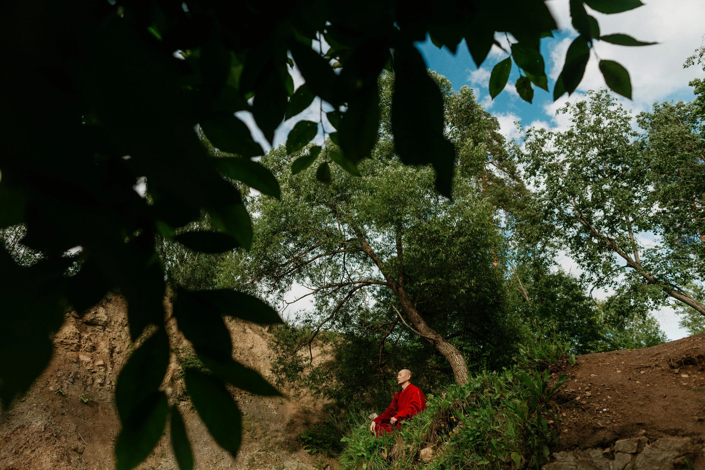 an older woman is standing by the tree