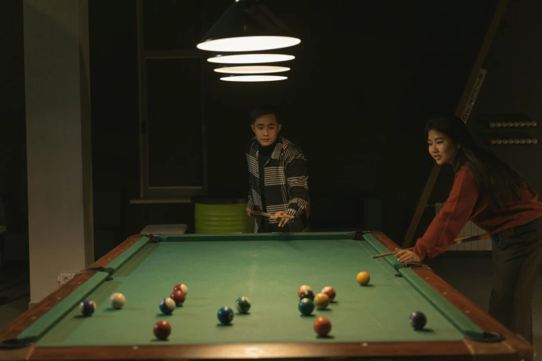 two children play a game of pool together