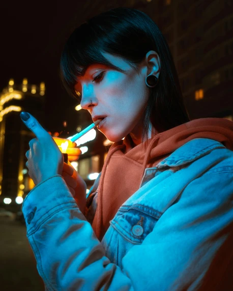 a young woman is texting on her cell phone at night
