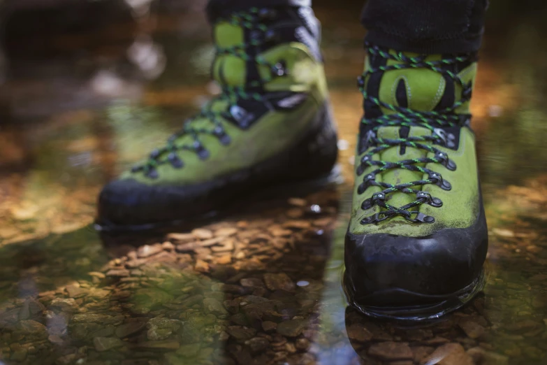 a couple of green shoes on top of a dirt ground