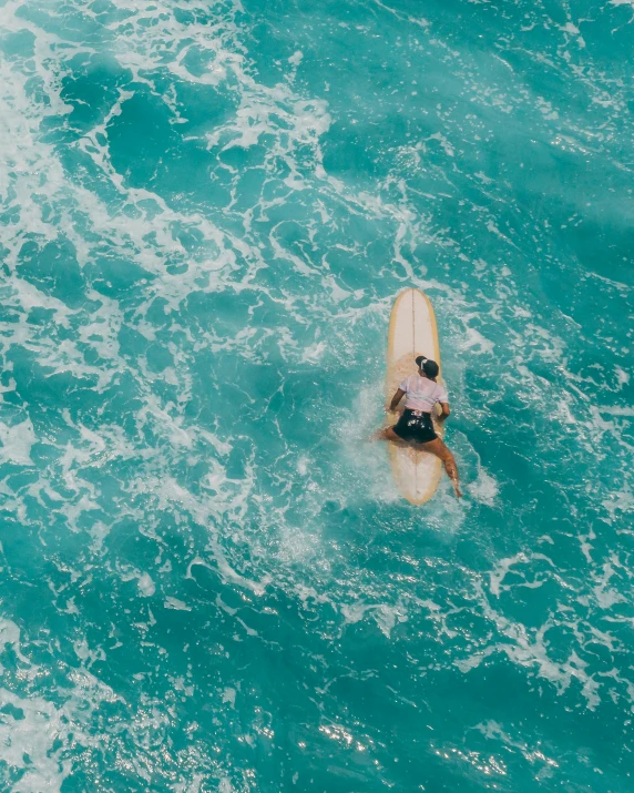 two people in a body of water on a surfboard