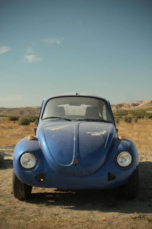 an old beetle car sits in the desert