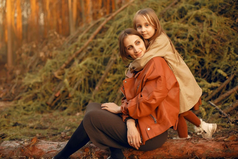 two little girls are sitting on a log