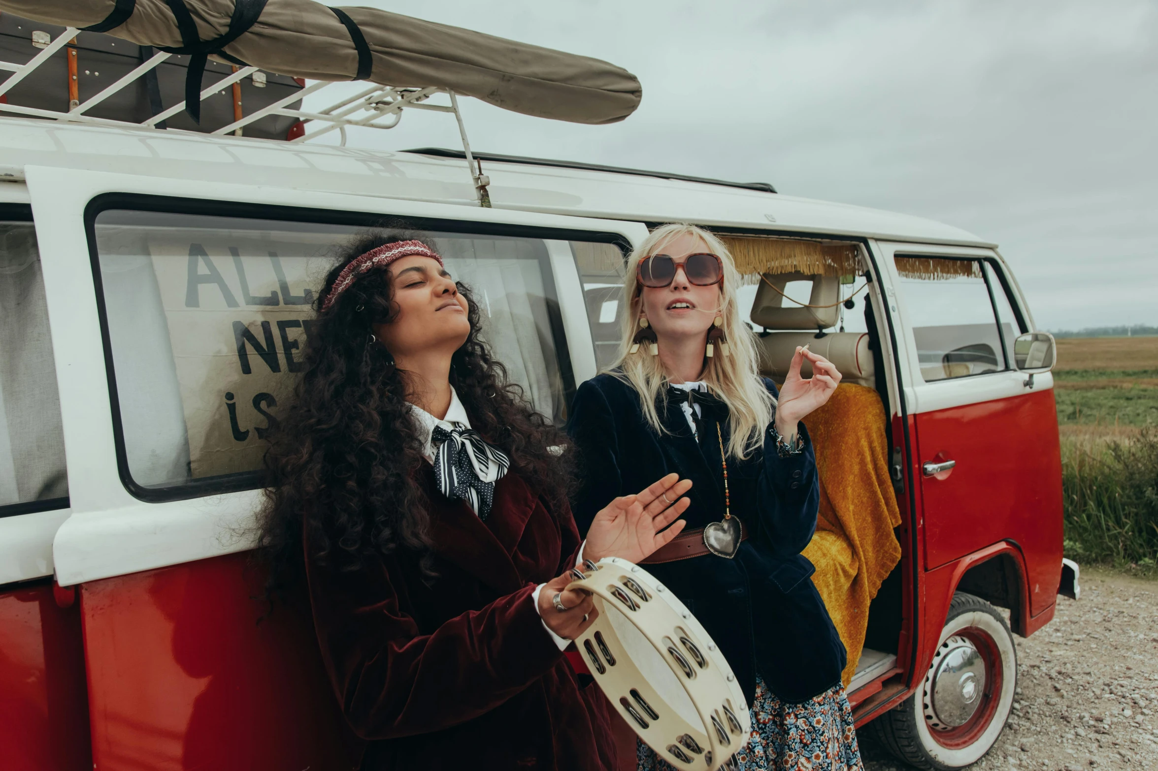 two women standing in front of a van talking