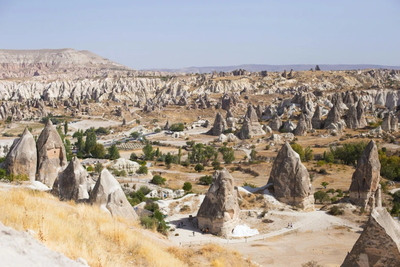 a wide open field of rock formations and trees