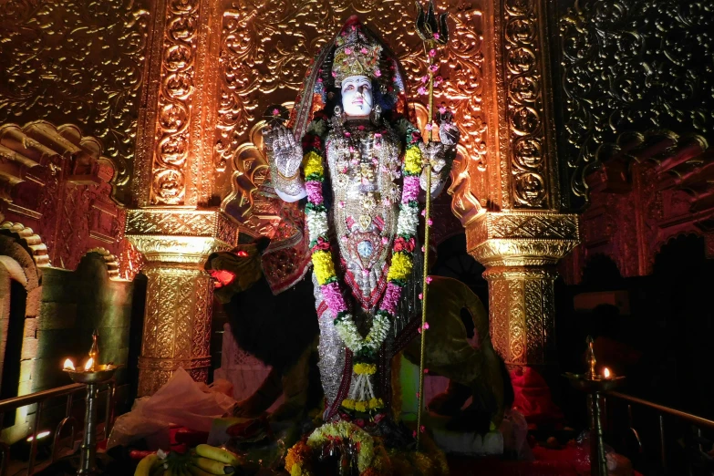 an idol sits in front of a decorated wall