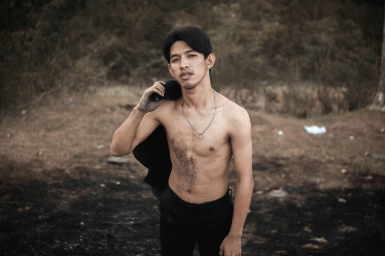 a shirtless man walks in an asian forest