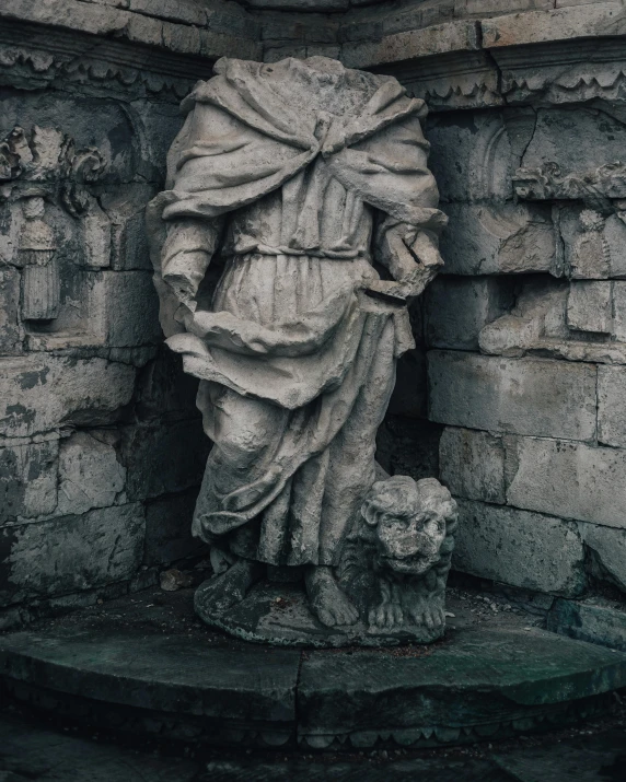 this stone statue is sitting next to a brick wall