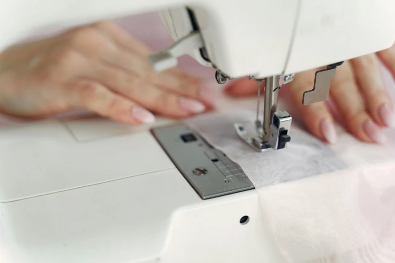 a person using a sewing machine to sew on clothing