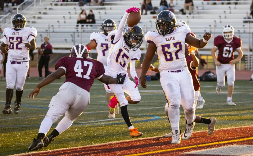 football players run and leap for the ball