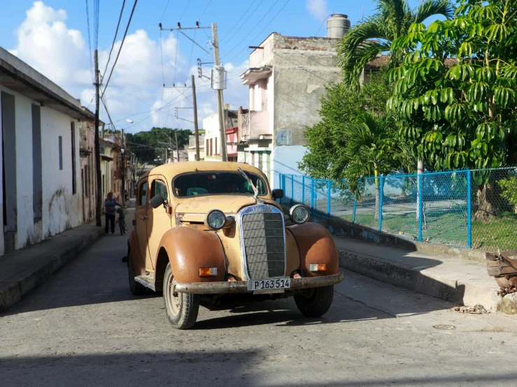 an old style car is parked next to a little building