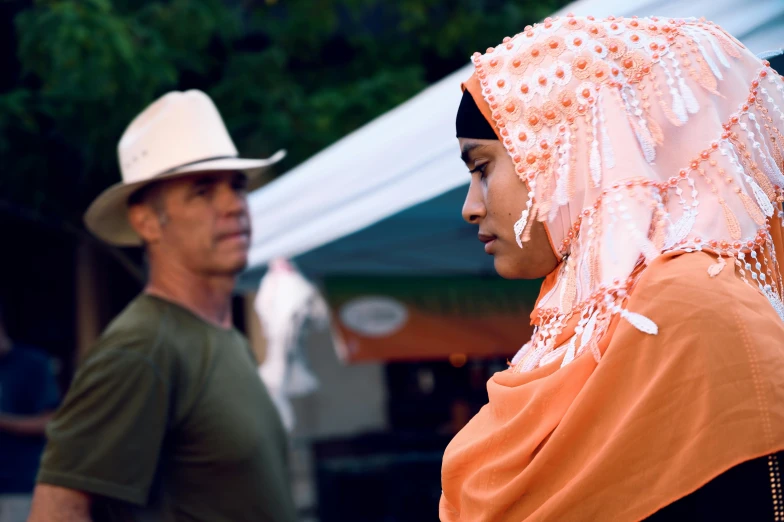 two people wearing headscarves at an outdoor market