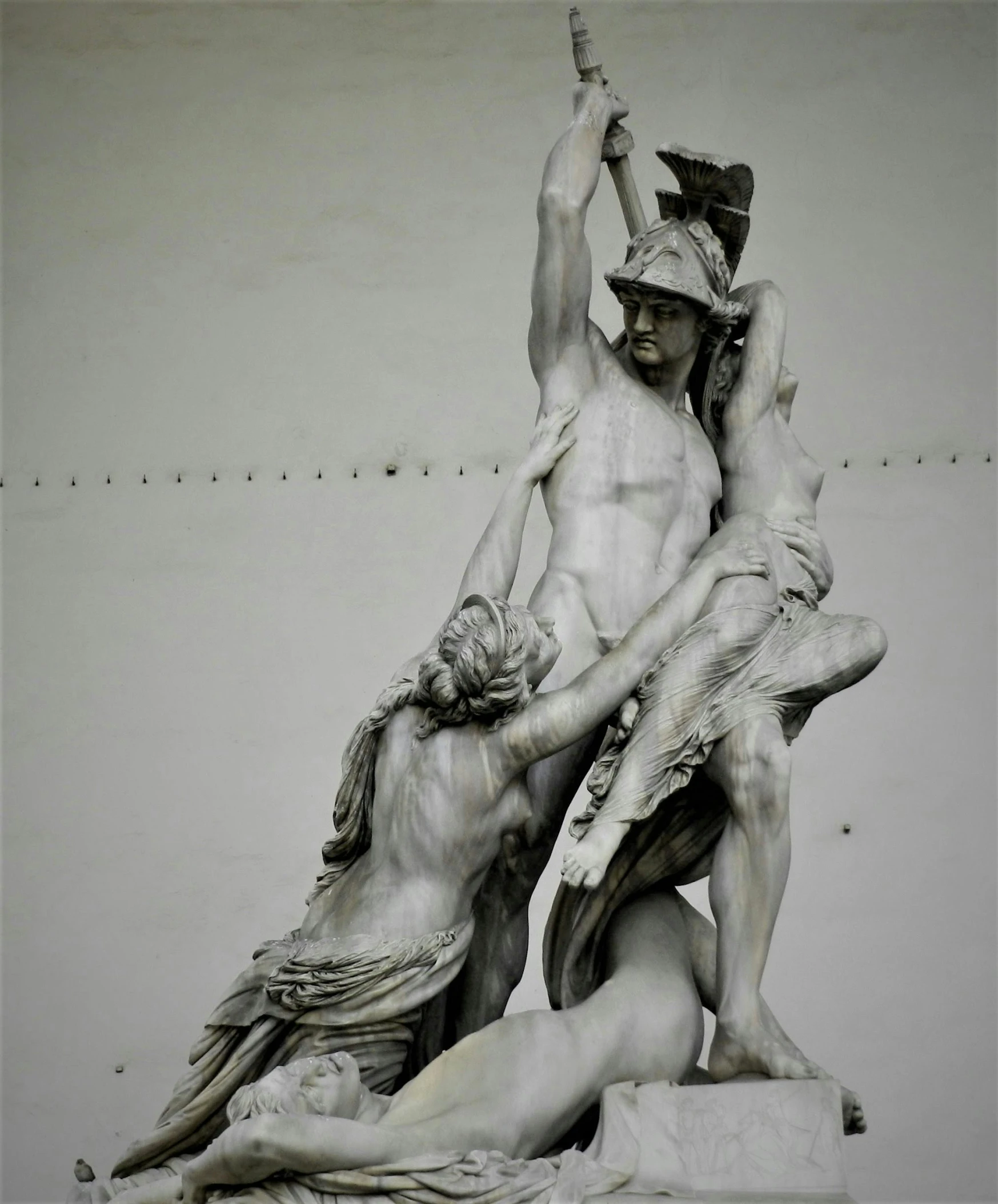 an artistic statue with three people climbing on them