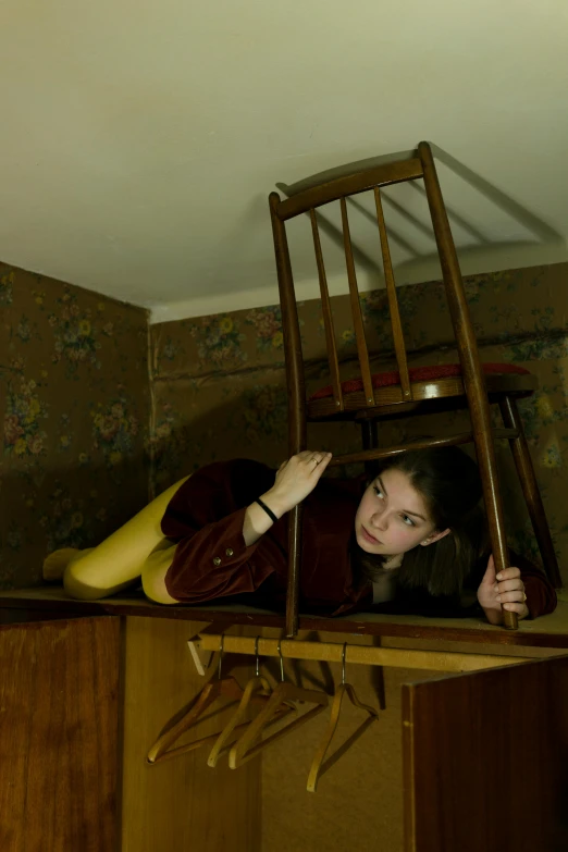 a woman in a chair and a ladder over her head