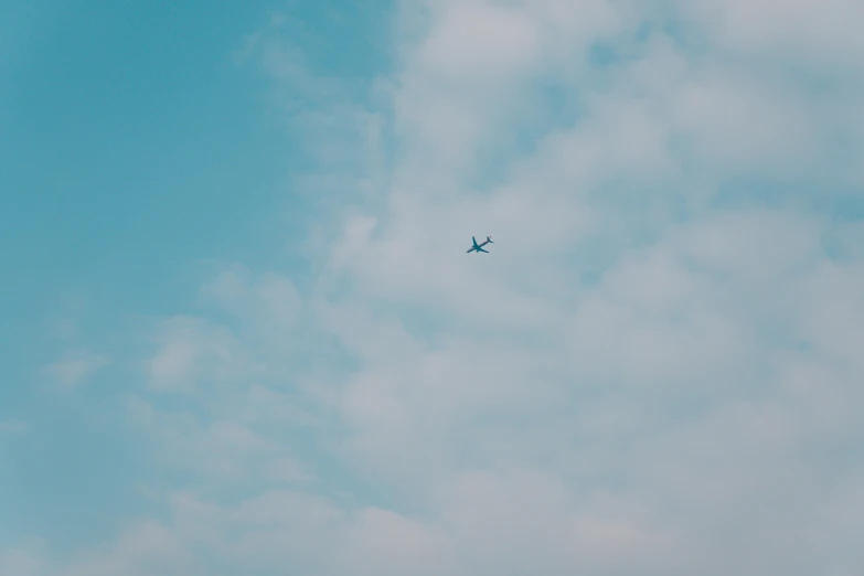 an airplane in the sky with clouds around it