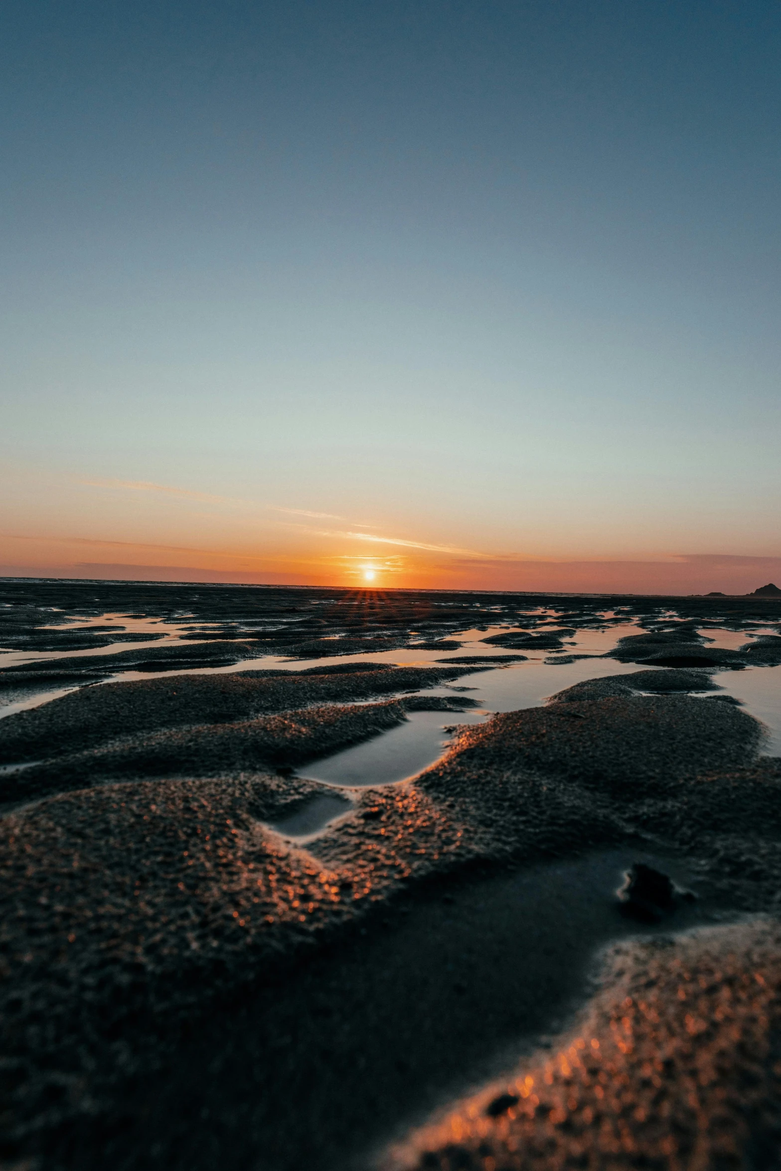 a picture taken at sunset with water running in the middle of the ground