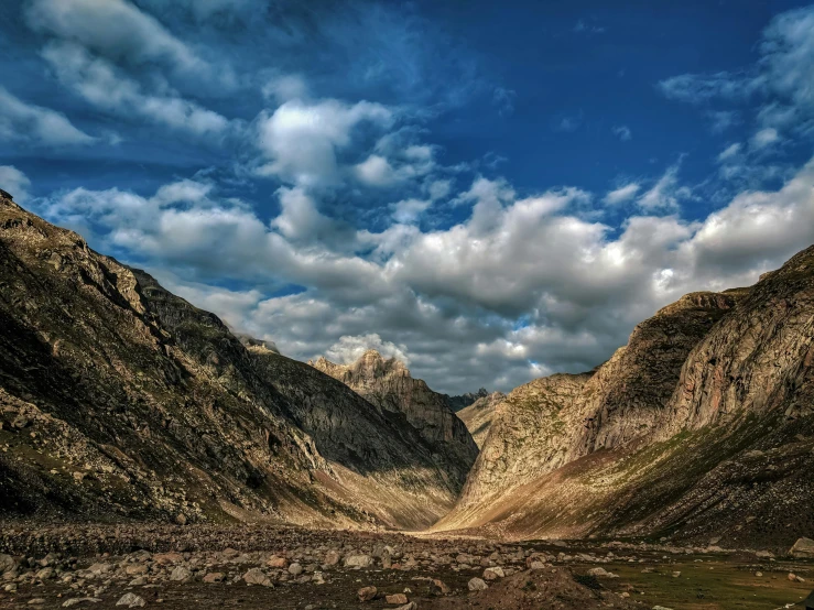 several hills that are surrounded by rocks and grass