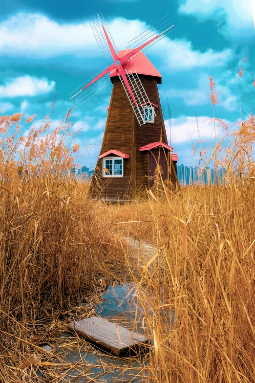 windmill with a red roof stands in the tall grass