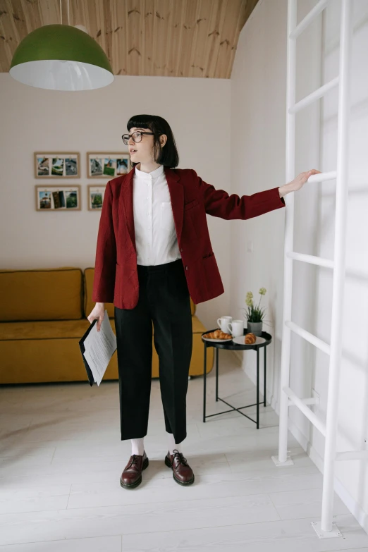 the woman standing next to a book shelf holds a purse