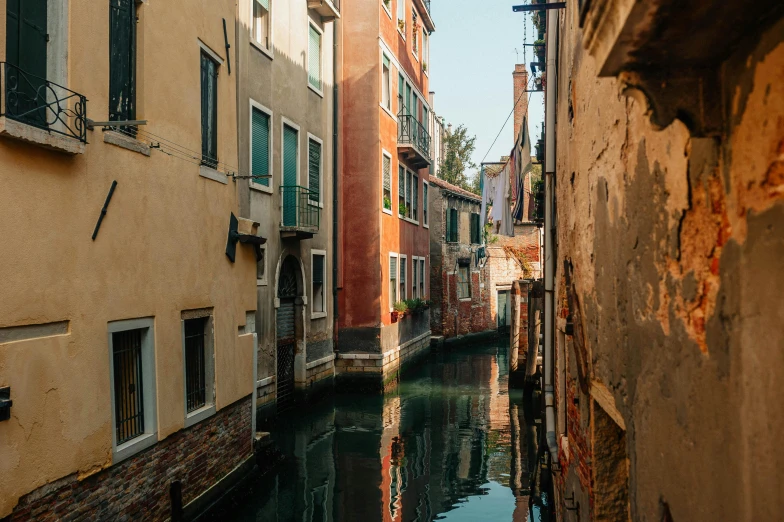 some water that is in a canal next to buildings