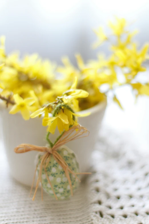 a cup filled with yellow flowers and a yellow planter