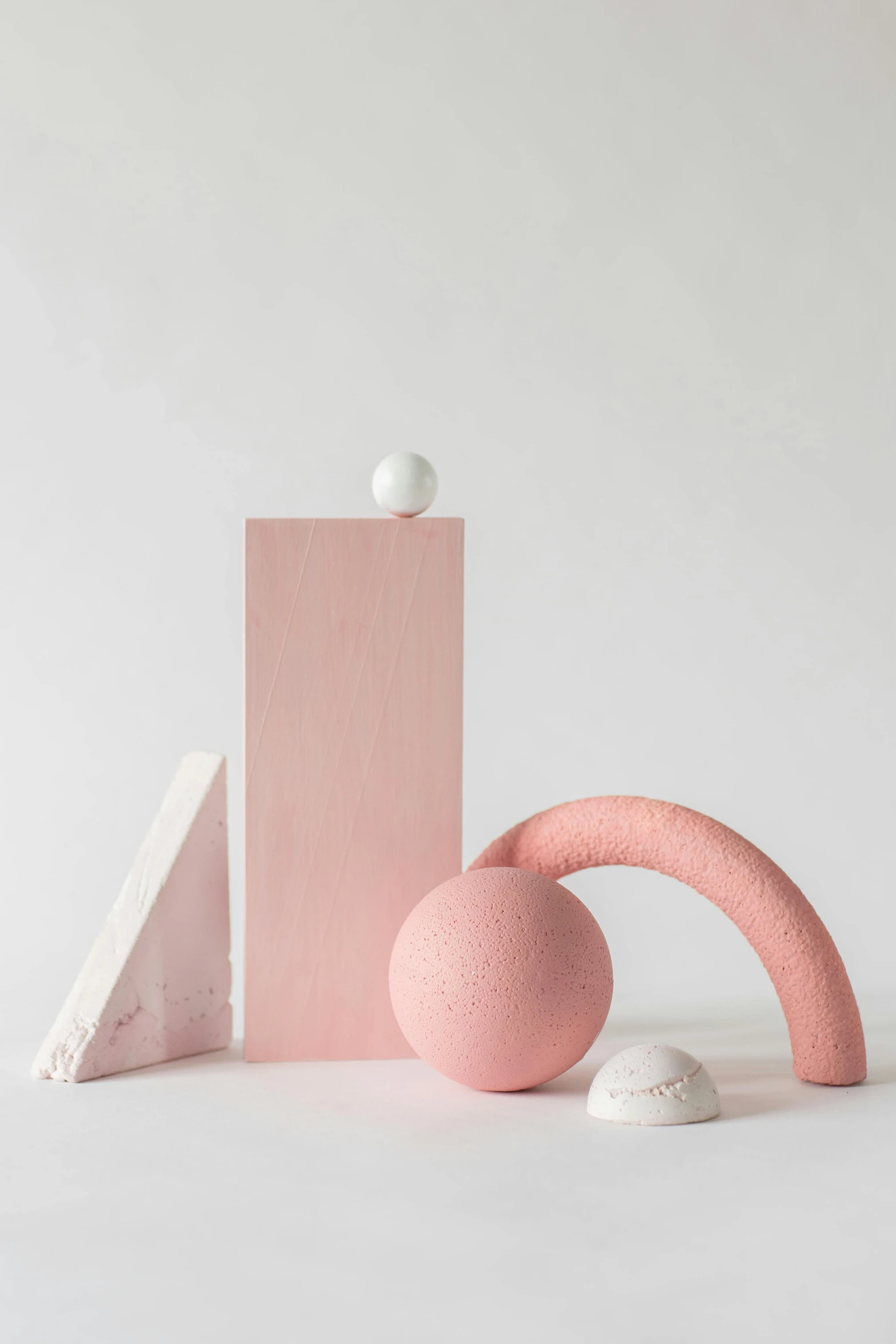 three pink sculptures made from materials such as plastic and wood